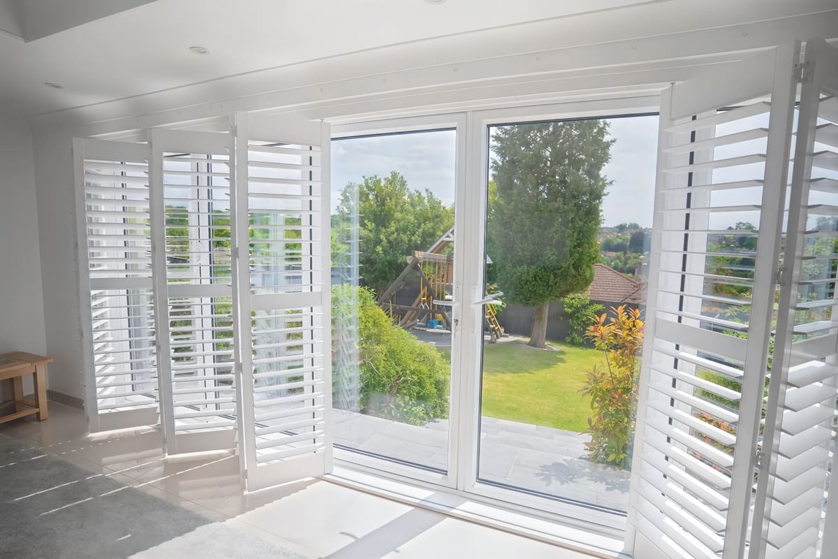 Tracked bifold shutters opened across a wide patio door